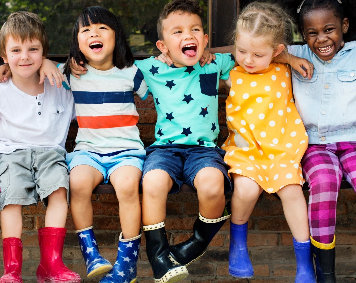 A group of children sitting on top of a bench.