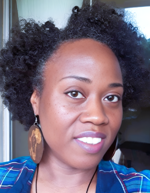 A woman with big hair and wearing earrings.