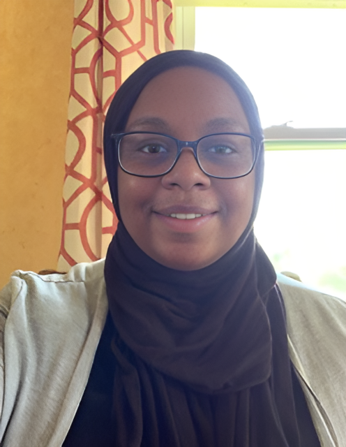 A woman wearing glasses and a hijab.